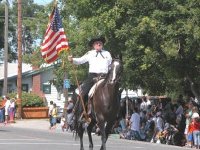Sheriff’s posse carrying a flag while riding a horse